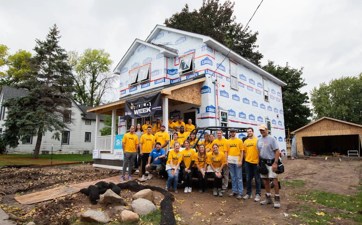 Vikings team next to Habitat for Humanity house in West St. Paul