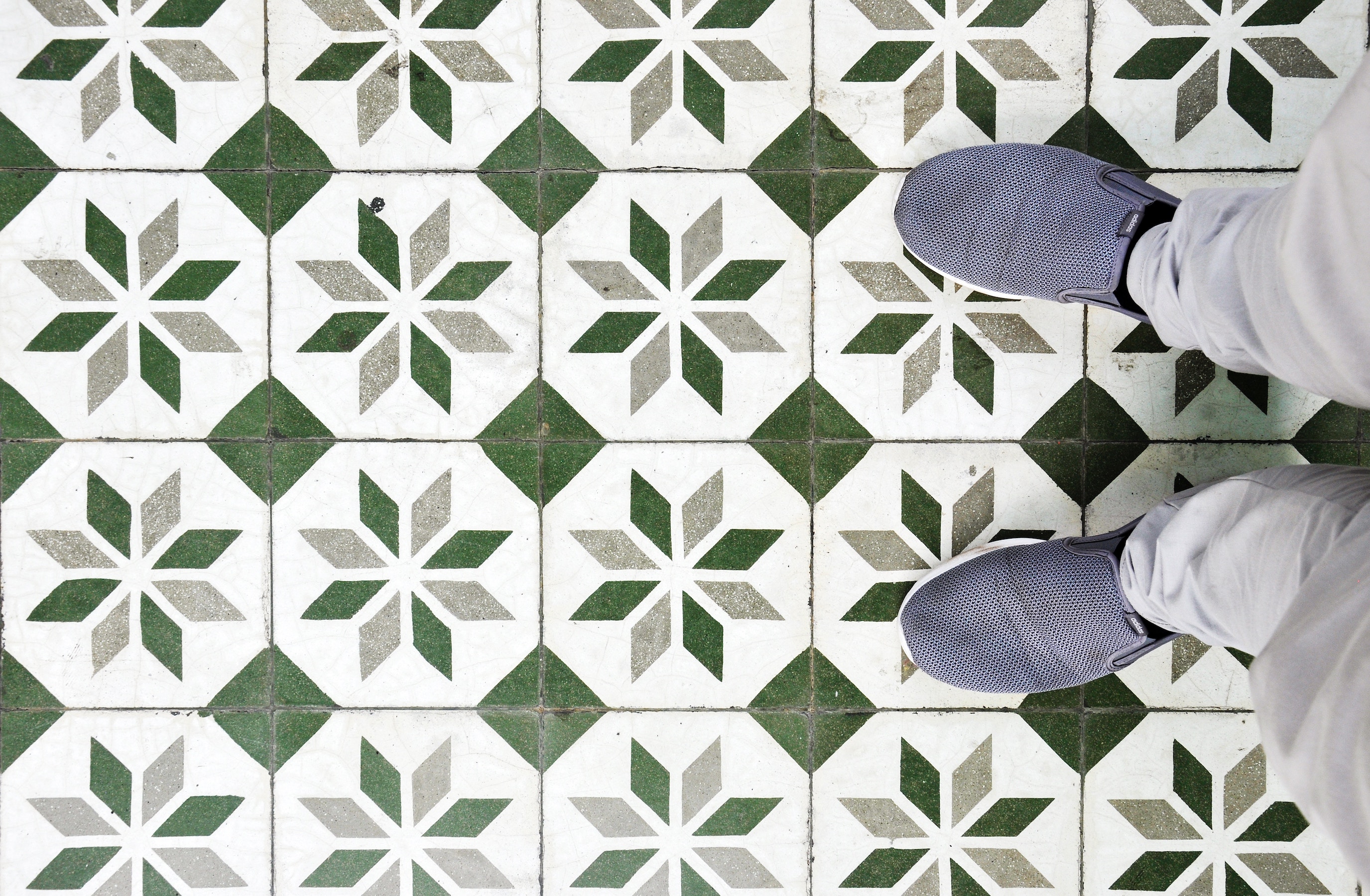 Patterned tile floor with person standing on it
