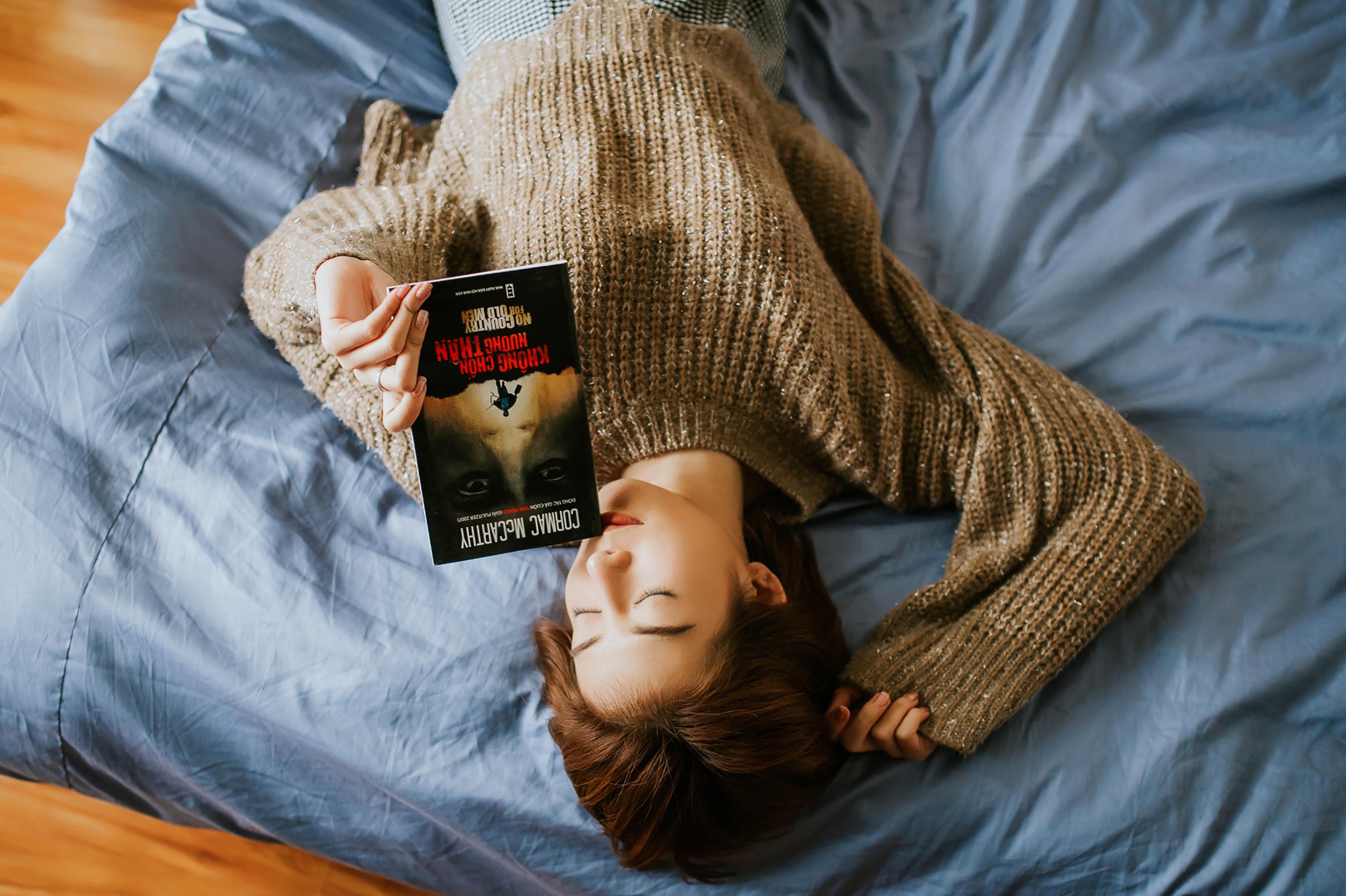 Woman relaxing in bed with a book