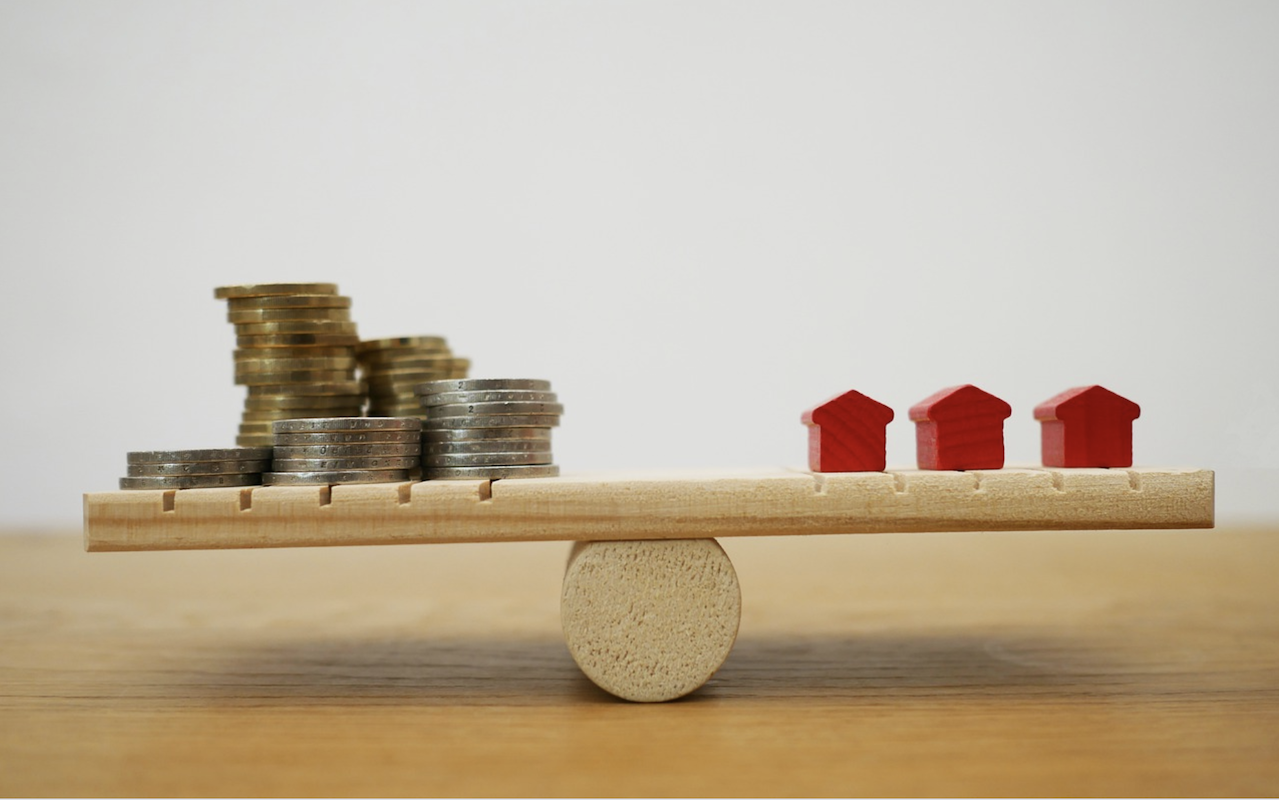 balancing act on see-saw to balance homes and money lending for builders