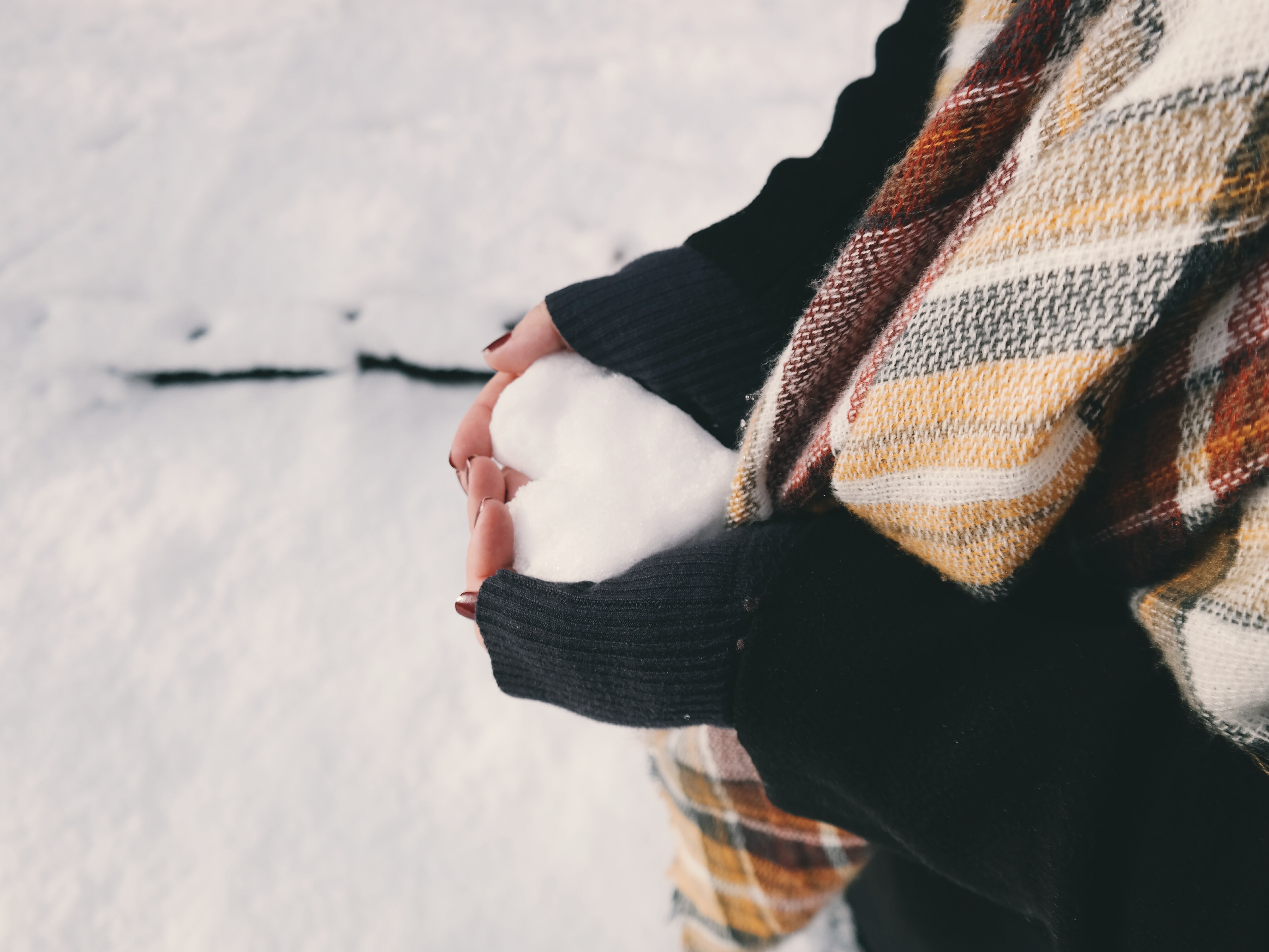 Person holding heart-shaped snowball