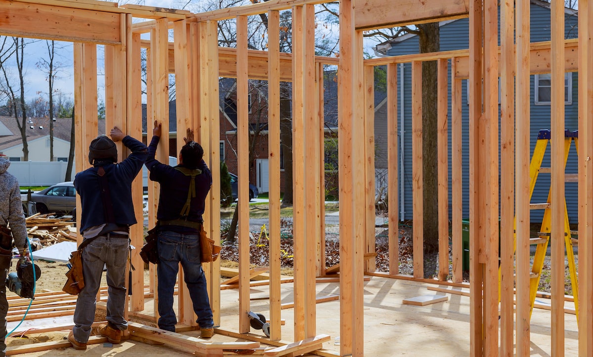 Builders framing new house with wood on jobsite
