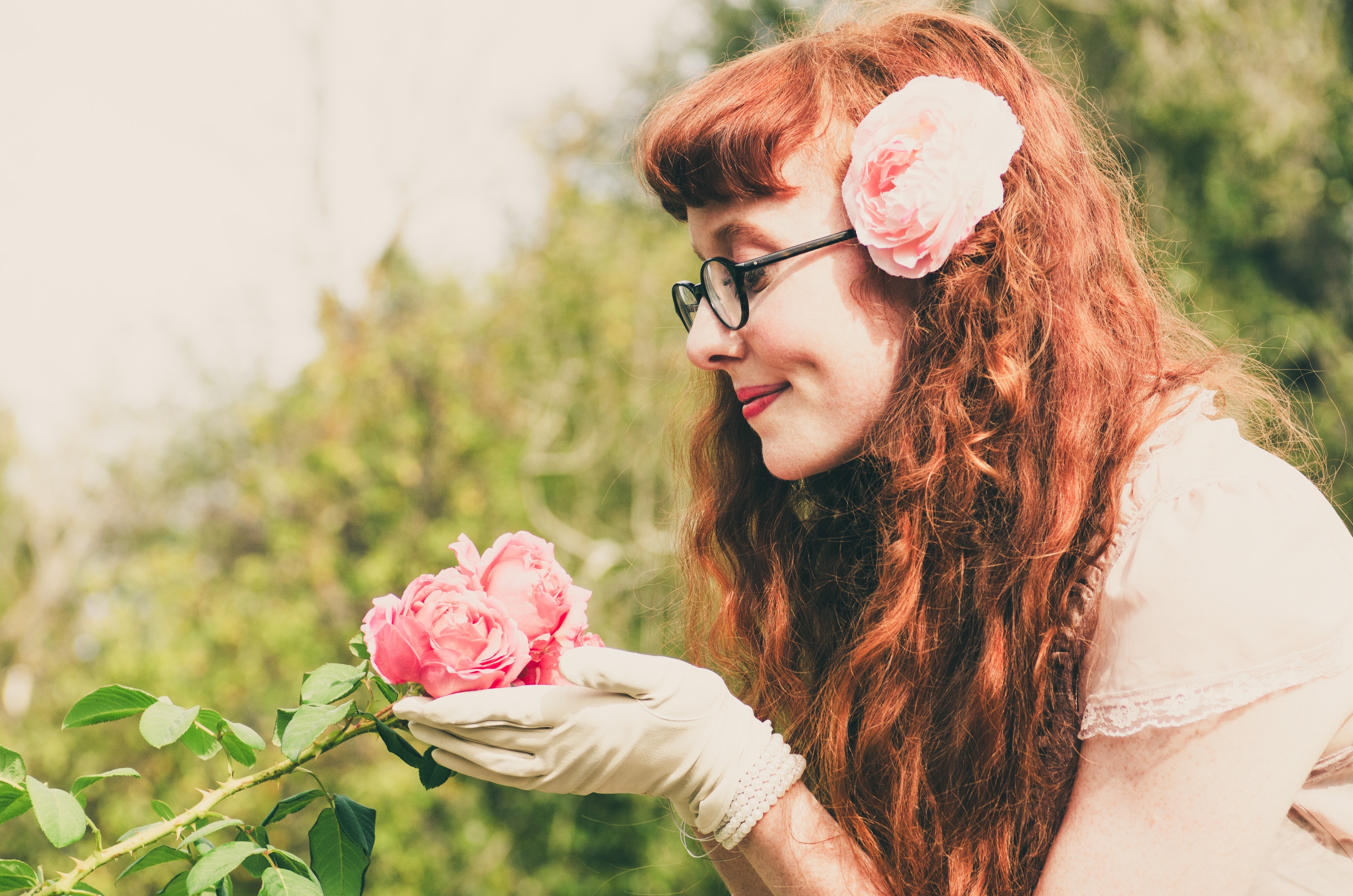 Woman smelling a rose in her garden enjoying the outdoors