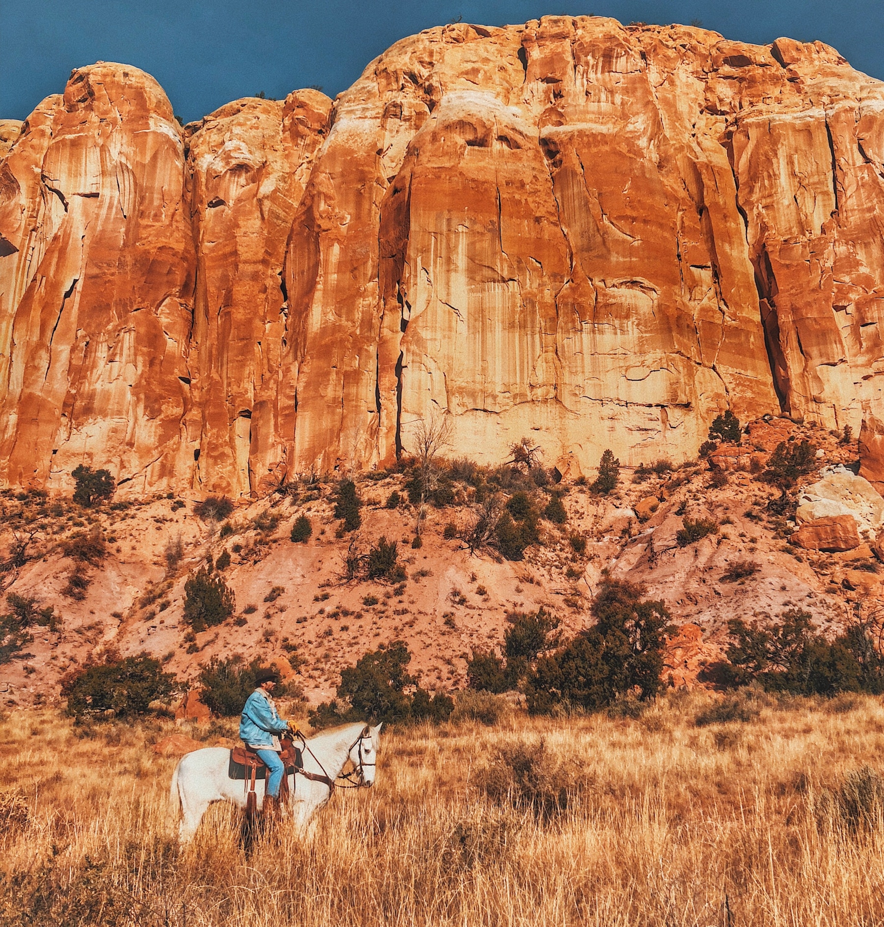 Man on horse outside, desert landscape