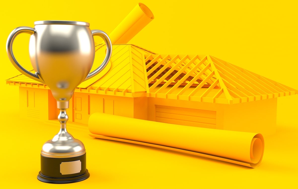 Trophy next to framed house and floor plans against bright yellow background