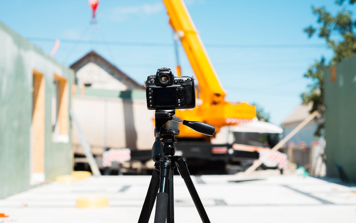 Filming video on tripod on construction site