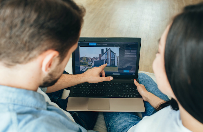 Couple looking at buying a home virtually on laptop