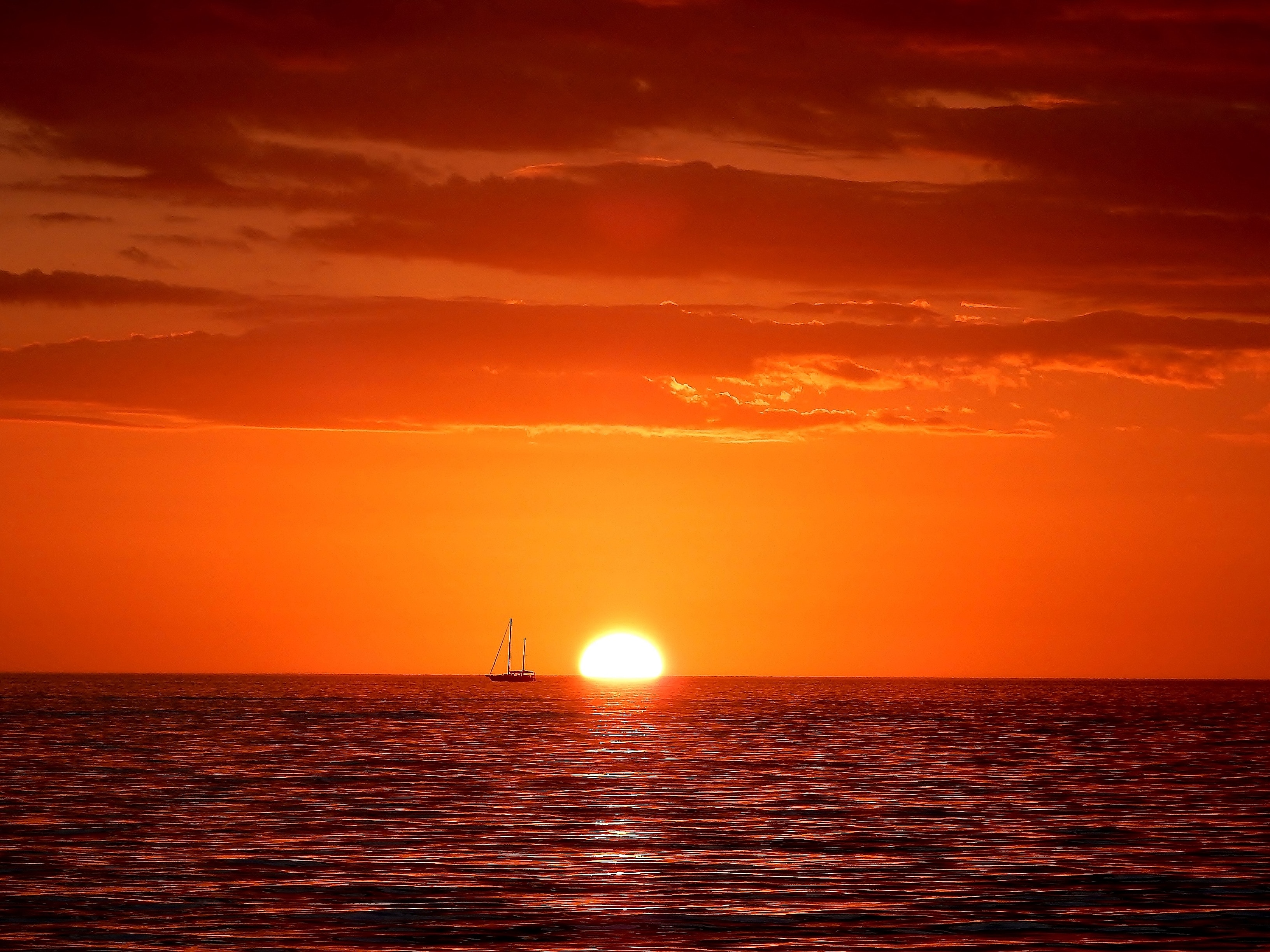 Sunrise with boat on the horizon on the ocean