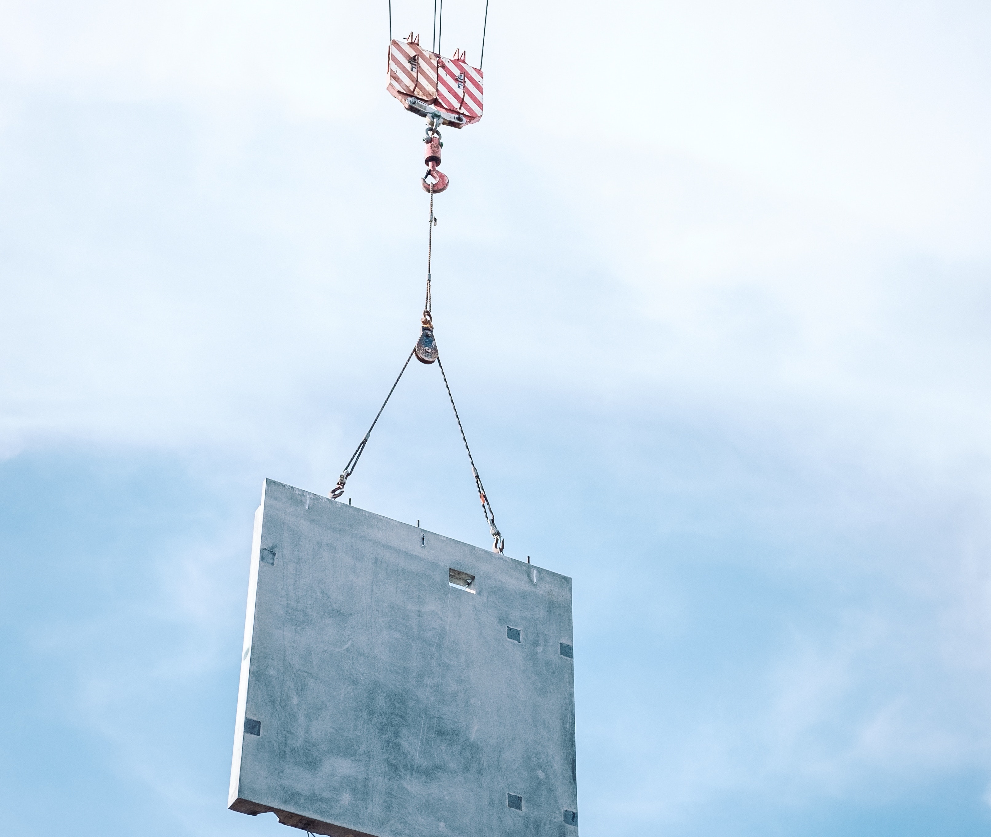 Prefab wall panel being lowered into place by a crane