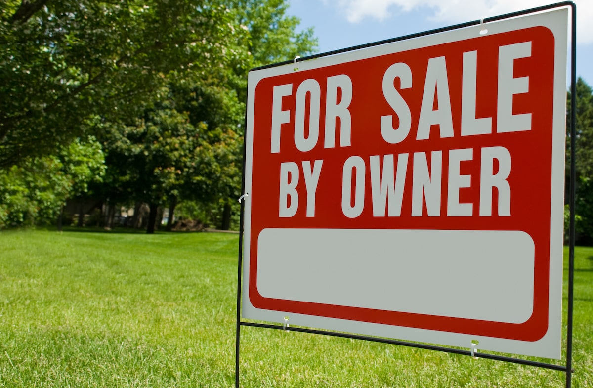 For sale by owner sign on residential lawn