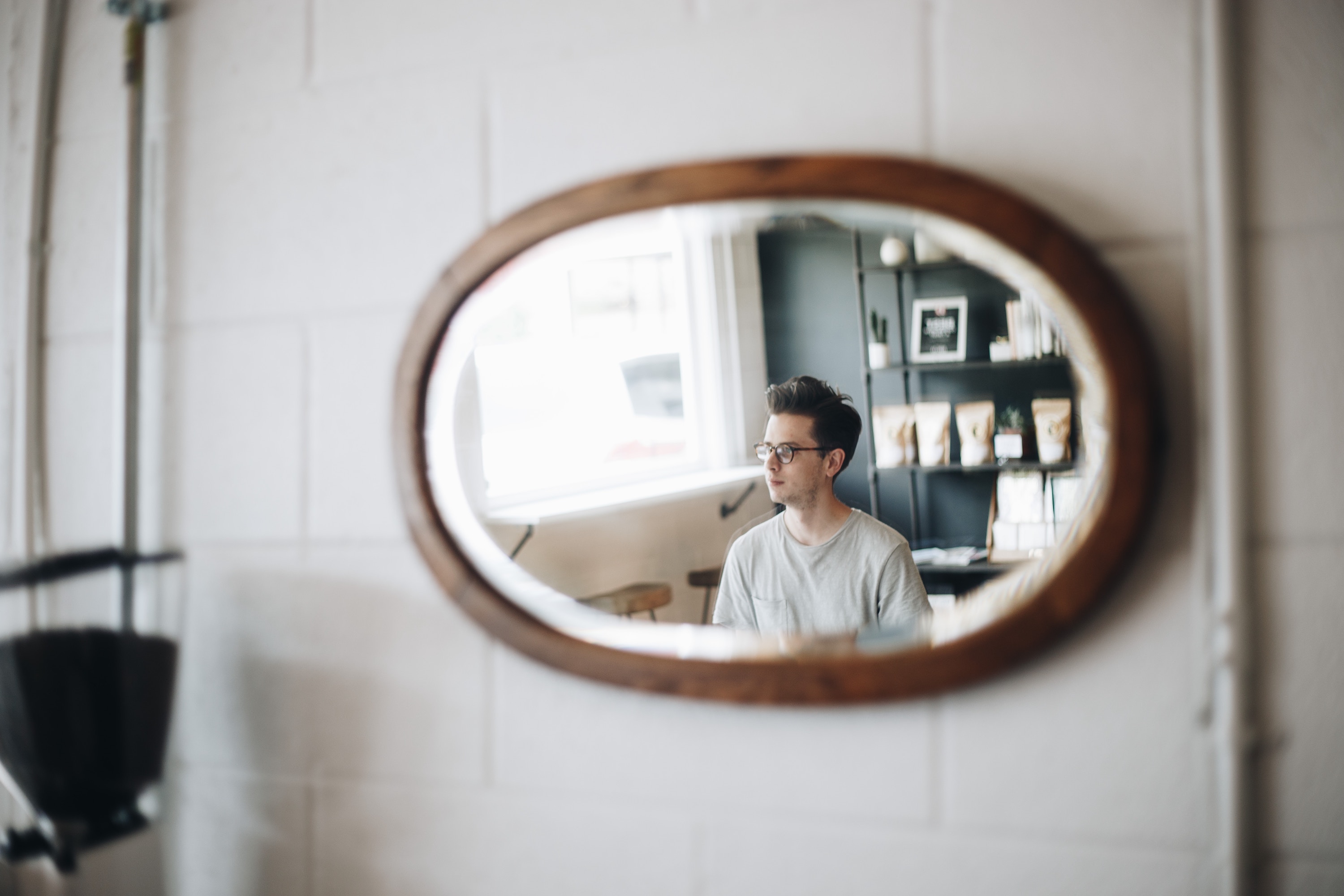 Young man in café as viewed through a mirror