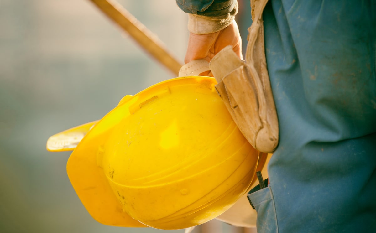 Home builder holding yellow hard hat