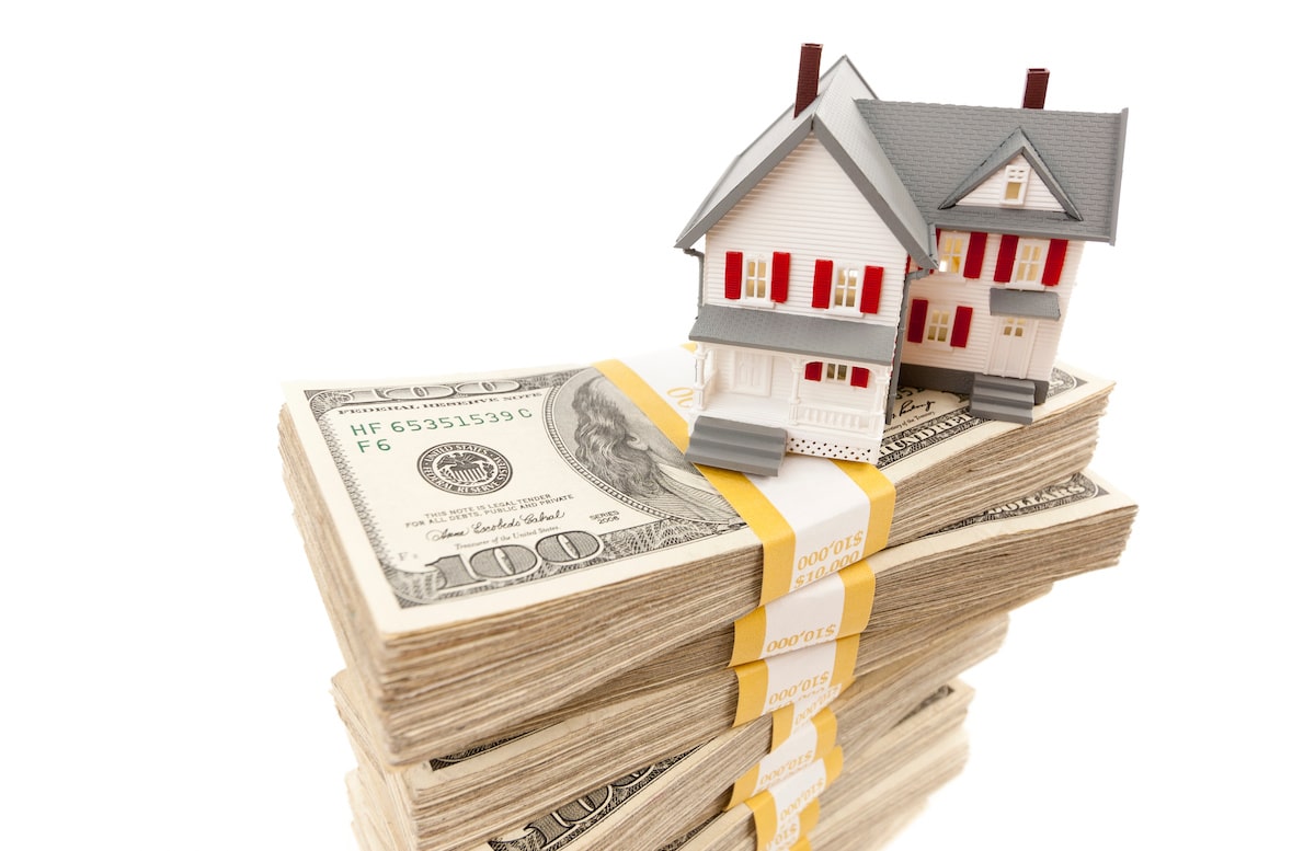 Home model on stack of money