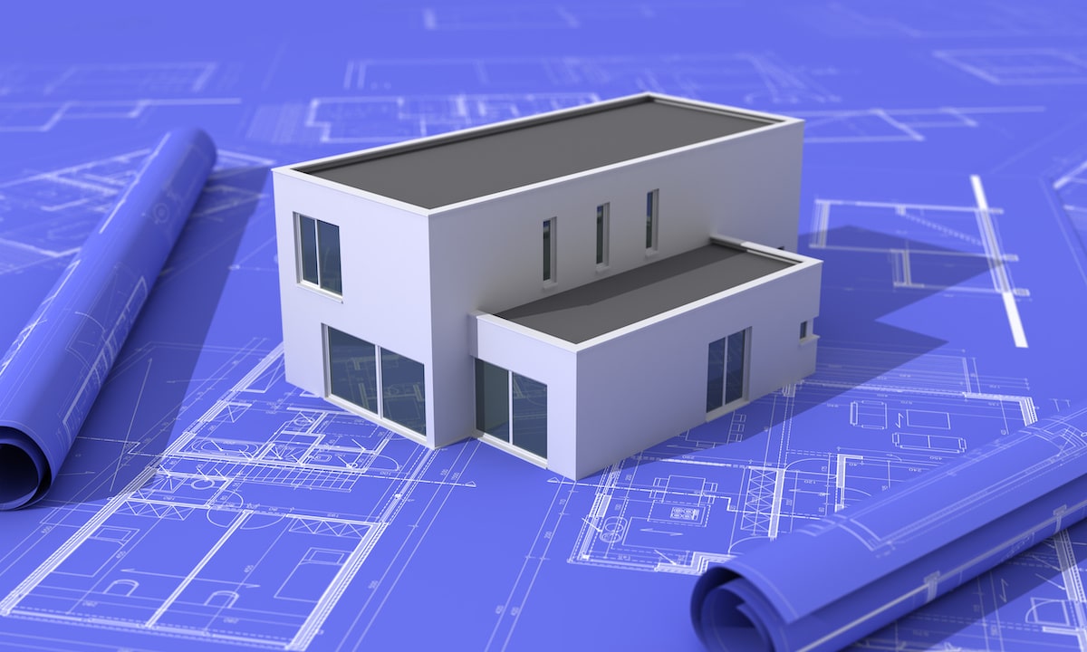 Modern white house model on construction blueprints