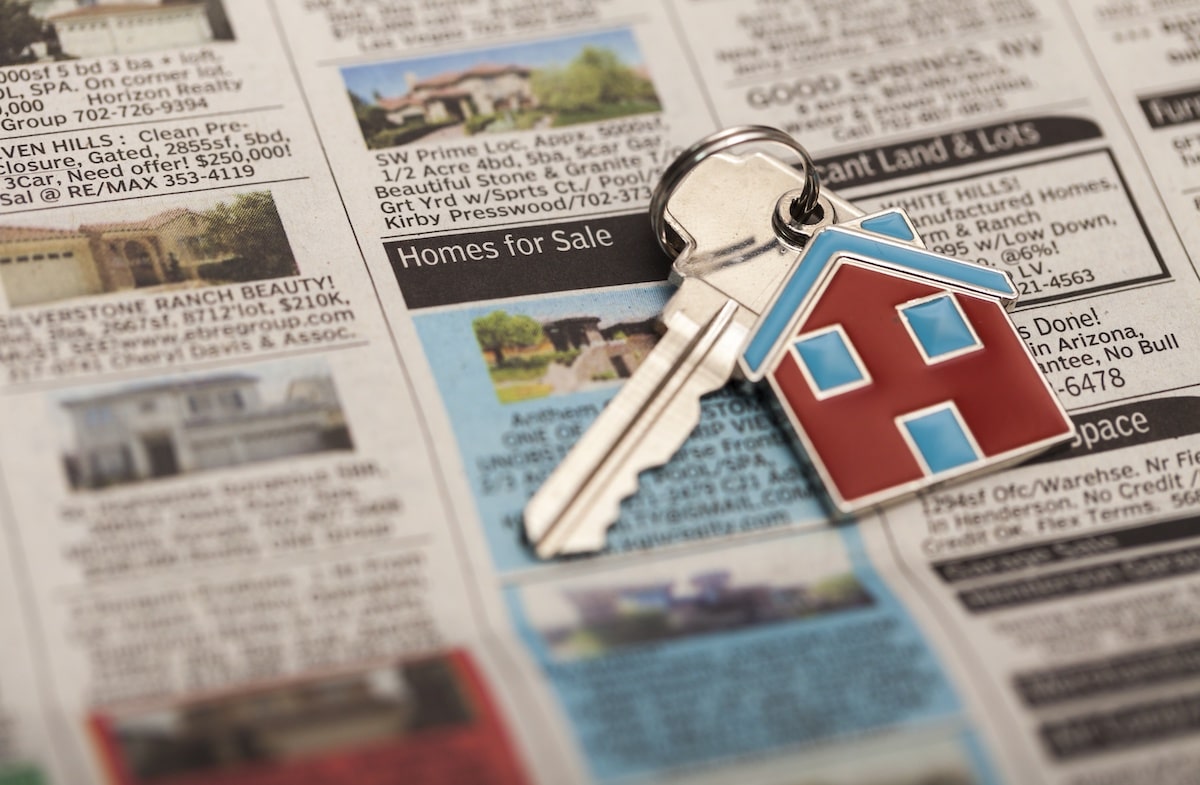 House keys on top of home listings in newspaper
