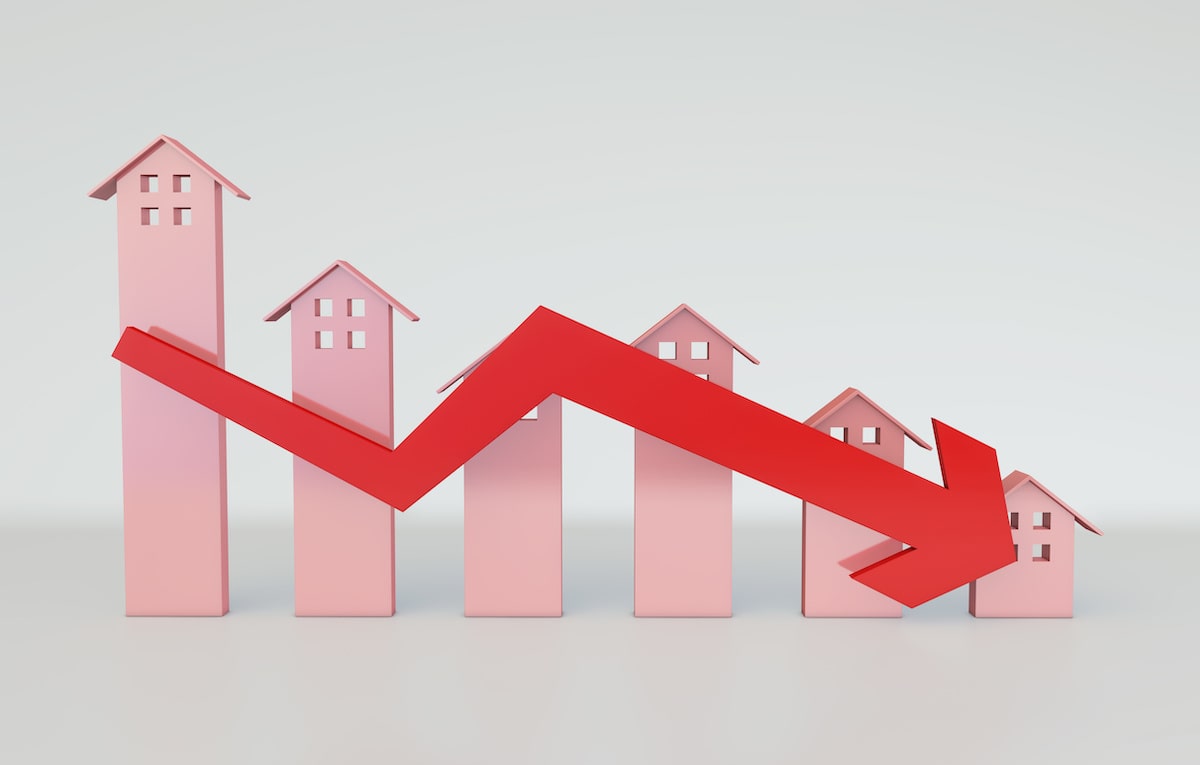 Falling red arrow against bar graph with houses