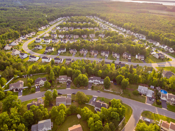 aerial view of housing subdivision surrounded by trees and green space