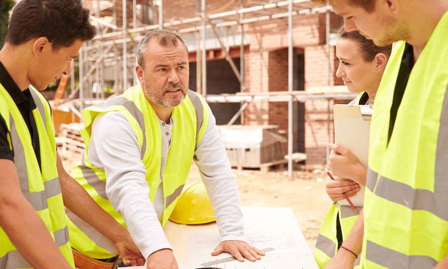 Builder telling teens about home building on construction site