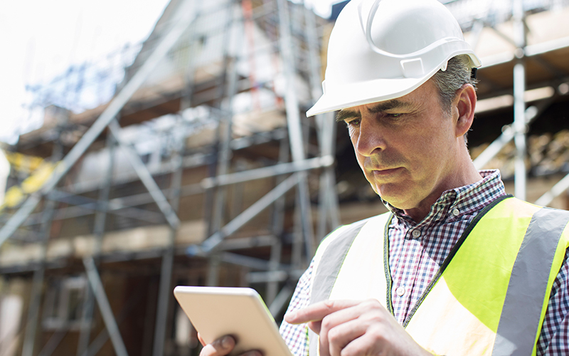 Man using BuildTools construction management software on tablet.