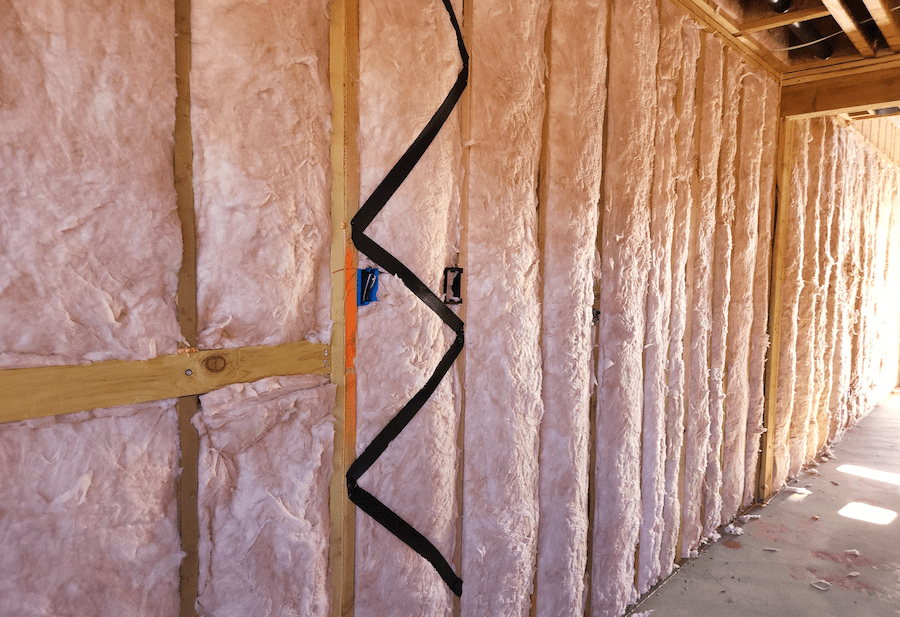 Fiberglass batts installed to insulate a home wall cavity