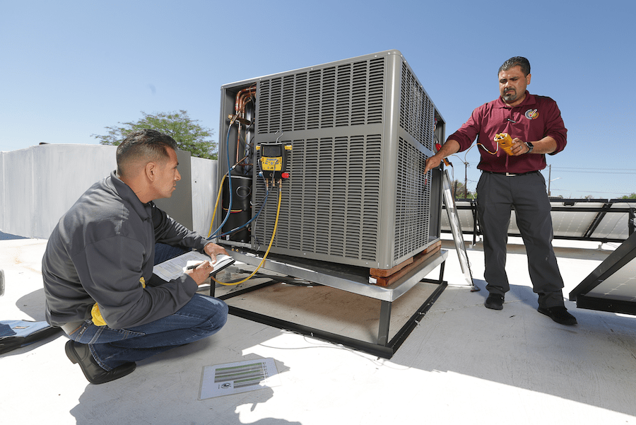 HVAC technicians using diagnostic tools to test an HVAC system for faults