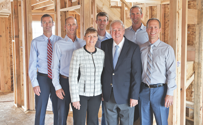Olthof Homes' management team standing in one of the company's homes at the framing stage