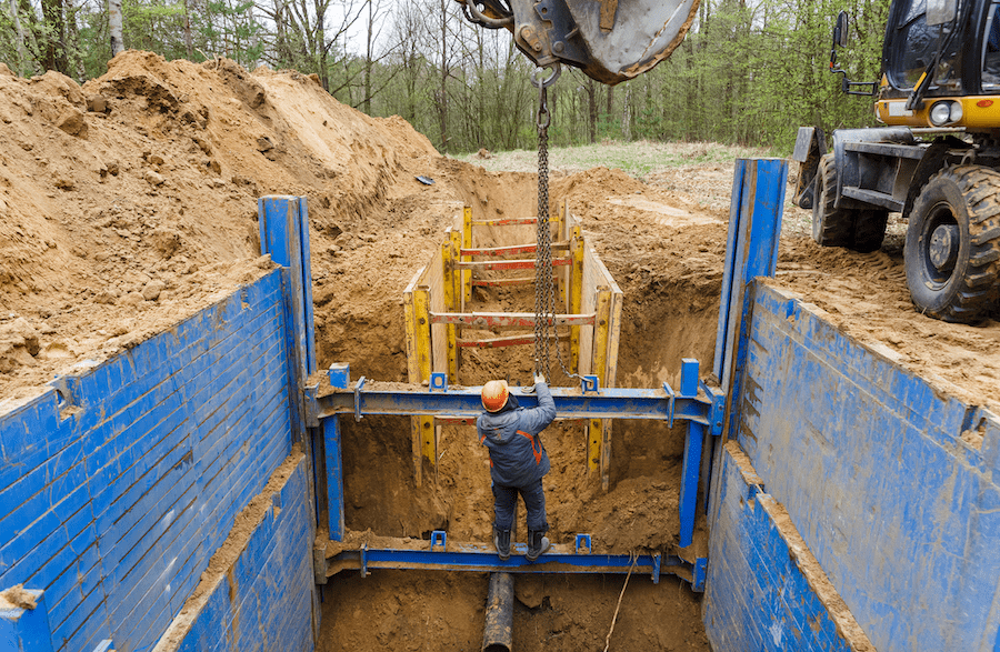 Trench box installation on a construction jobsite for trench shoring and safety