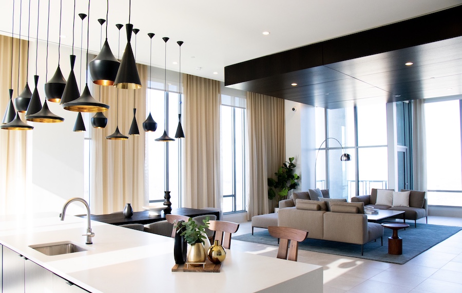 Black pendant task lighting adds a sculptural feel to the open-plan kitchen/living space