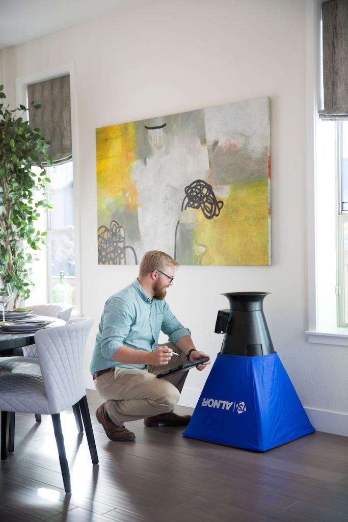 Thrive Home Builders Nathan Kahre measures a vent hood for flow and indoor air quality