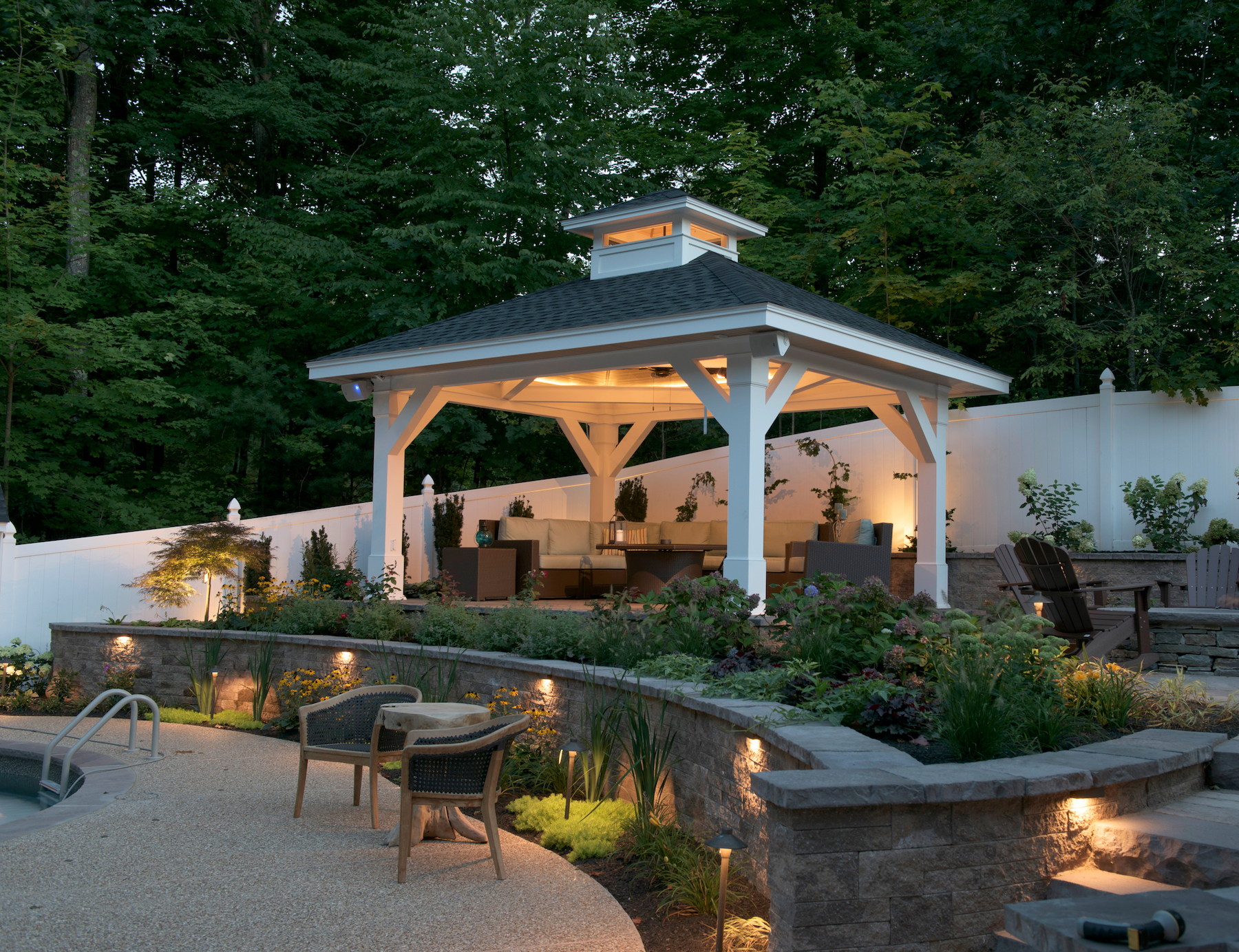 Warm lighting, ample seating, and a covered area made with Kleer trim and column wraps help make this outdoor space inviting .