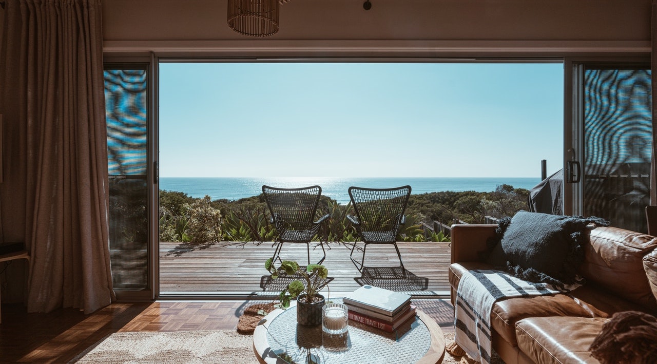 Two patio chairs overlooking the ocean in open floorplan beach house