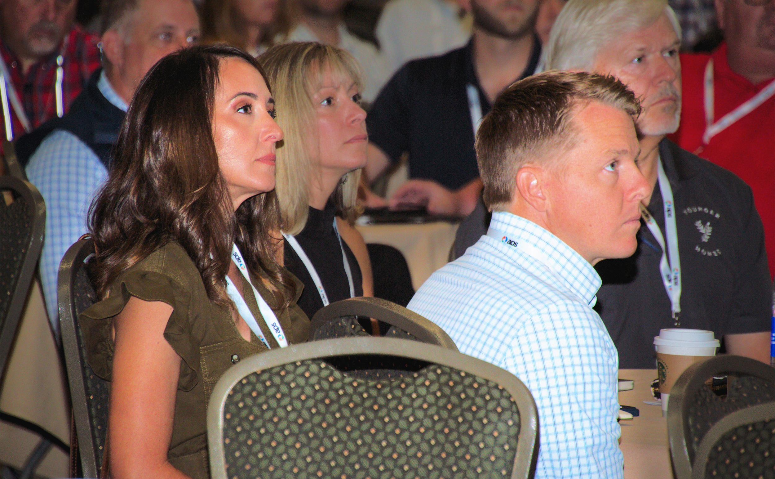 Danielle and Jesse Younger listening to presentation in crowded room