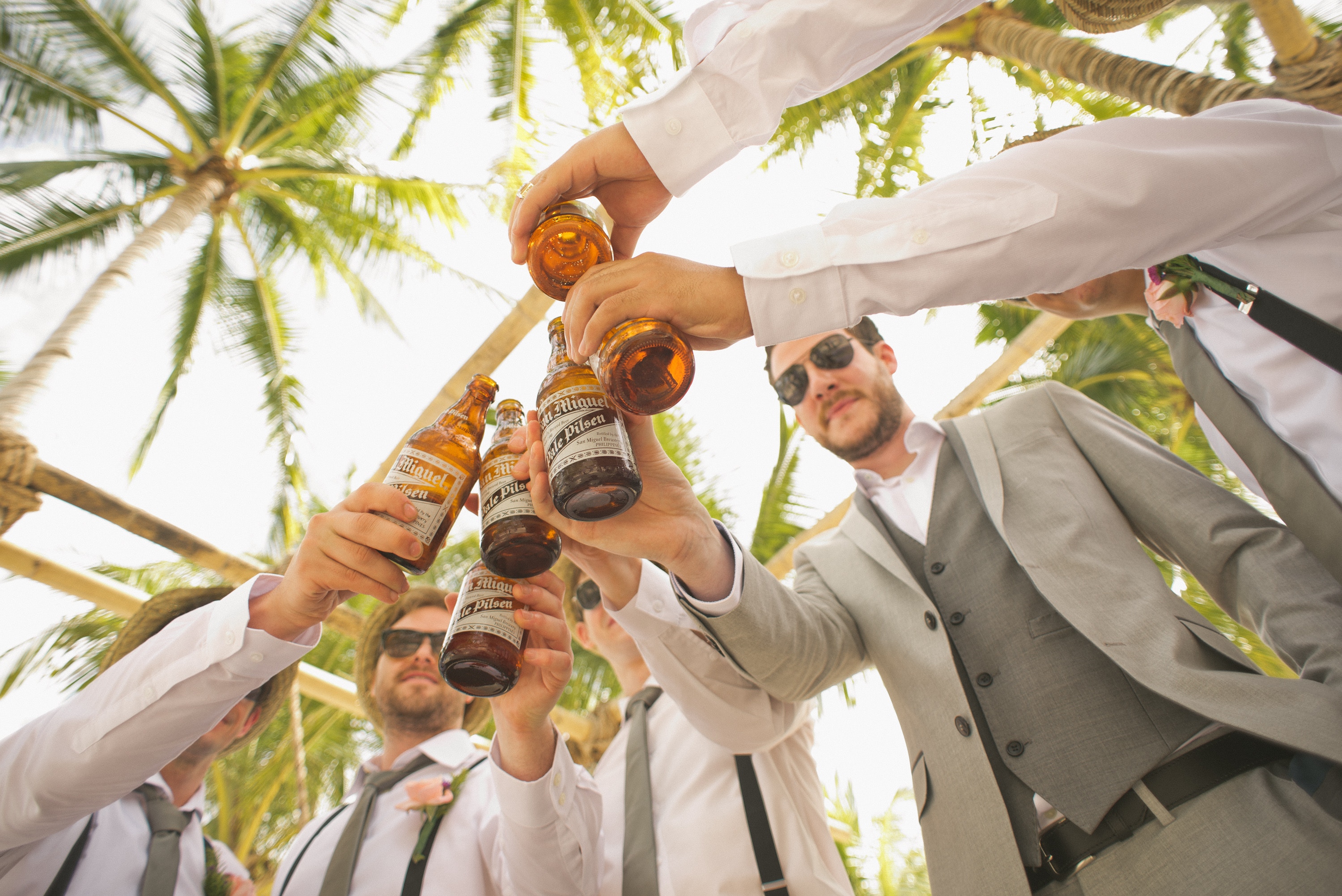 Group of men clinking beer bottles