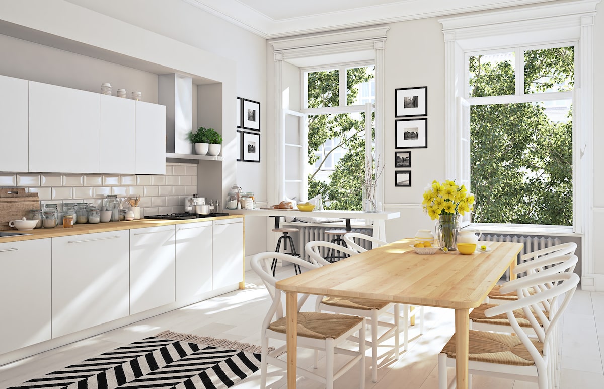 White kitchen with black and white rug accent and large windows