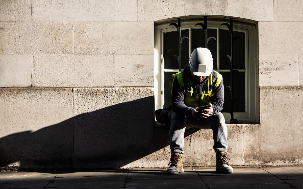 Construction worker looking at phone on break