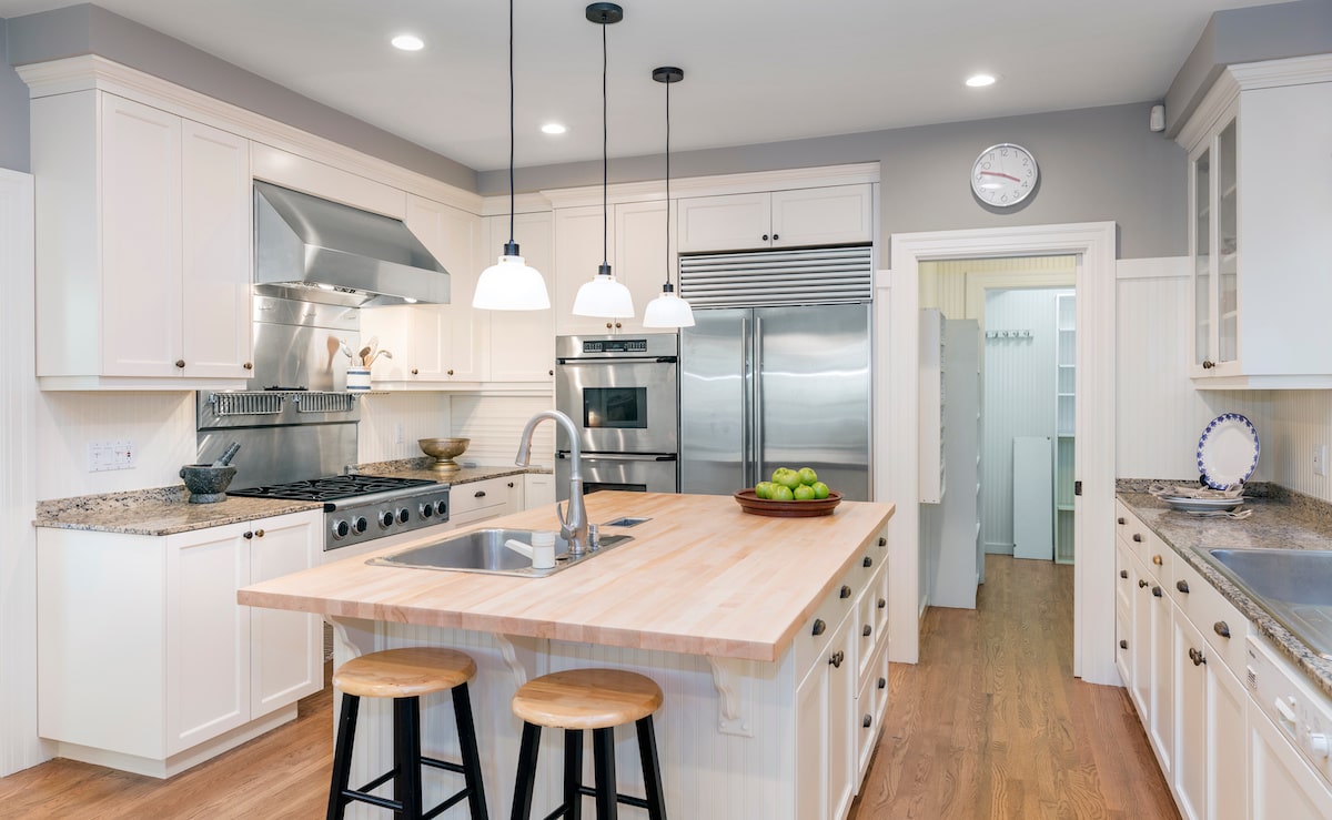 Modern white kitchen with central island and stainless steel appliances