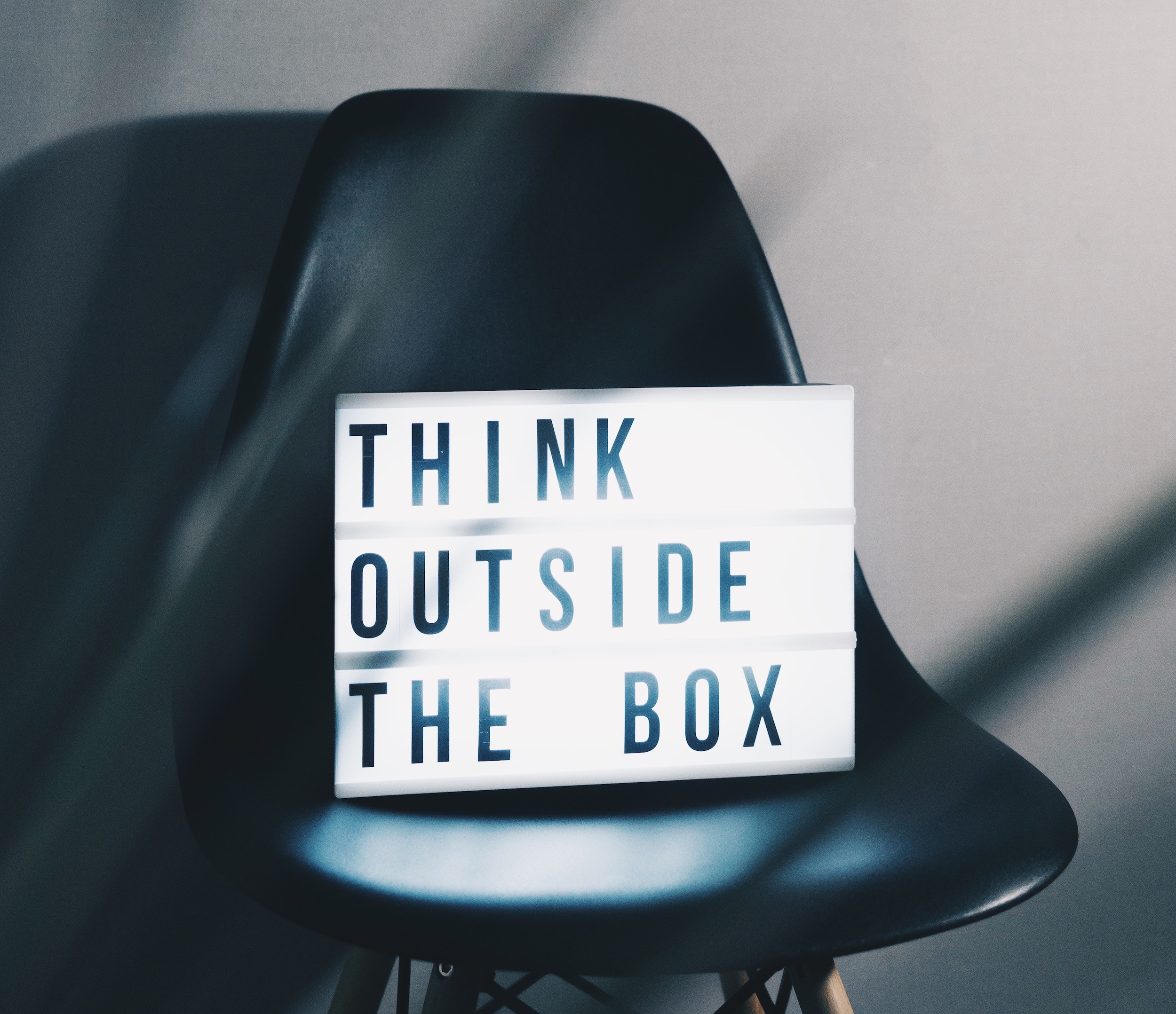 Chair with illuminated sign on it saying 'think outside the box'