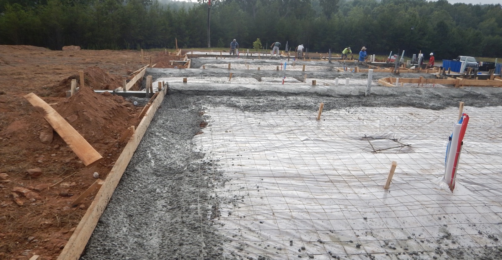 Work in progress on a slab-on-grade concrete foundation with rebar and poured concrete 