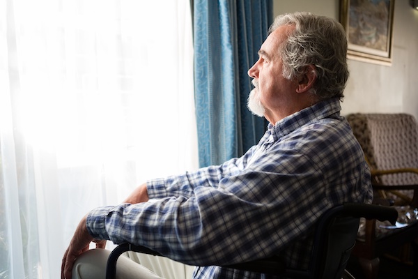 Retired man looking at window