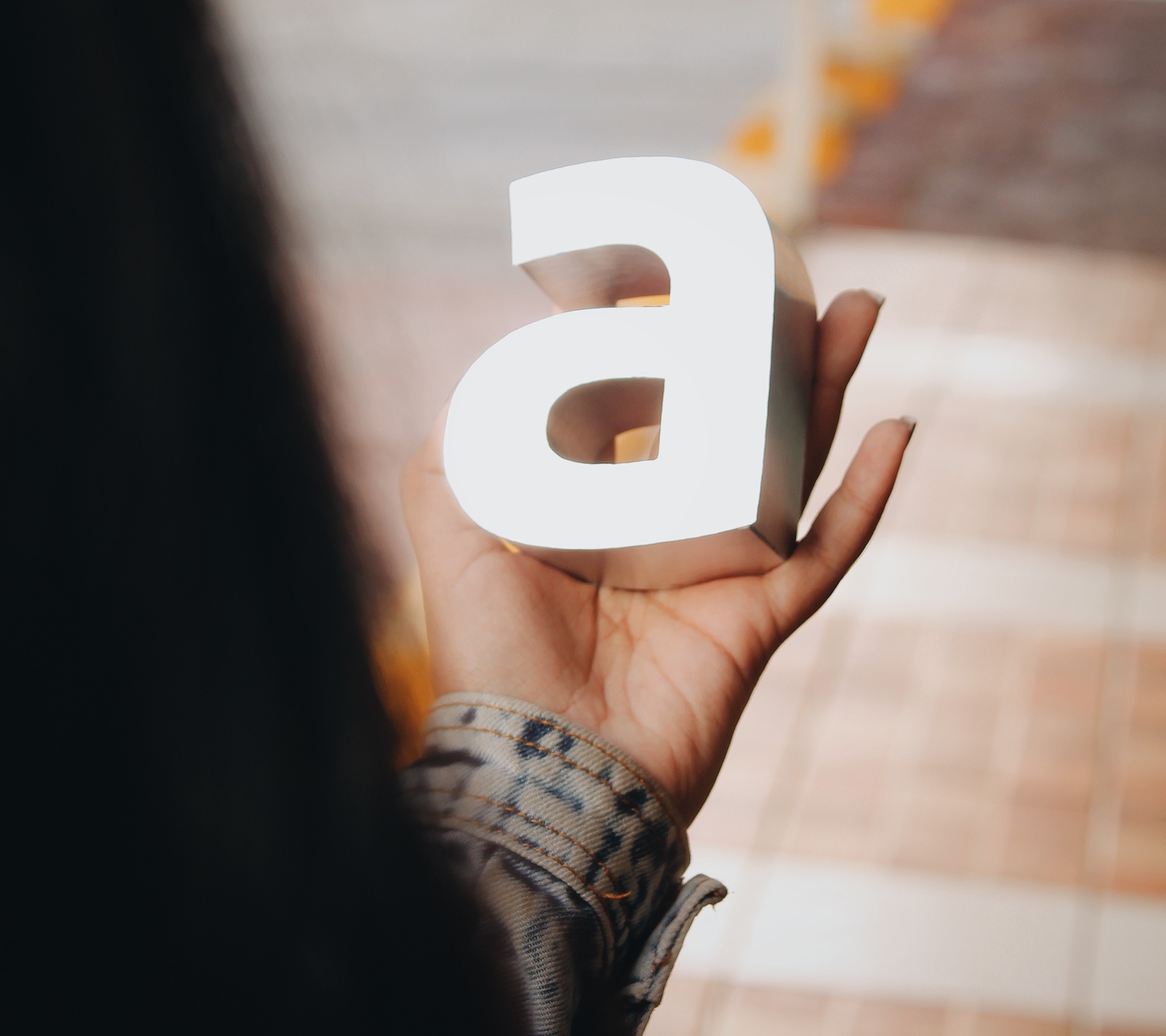Person holding an "A" letter in their hand