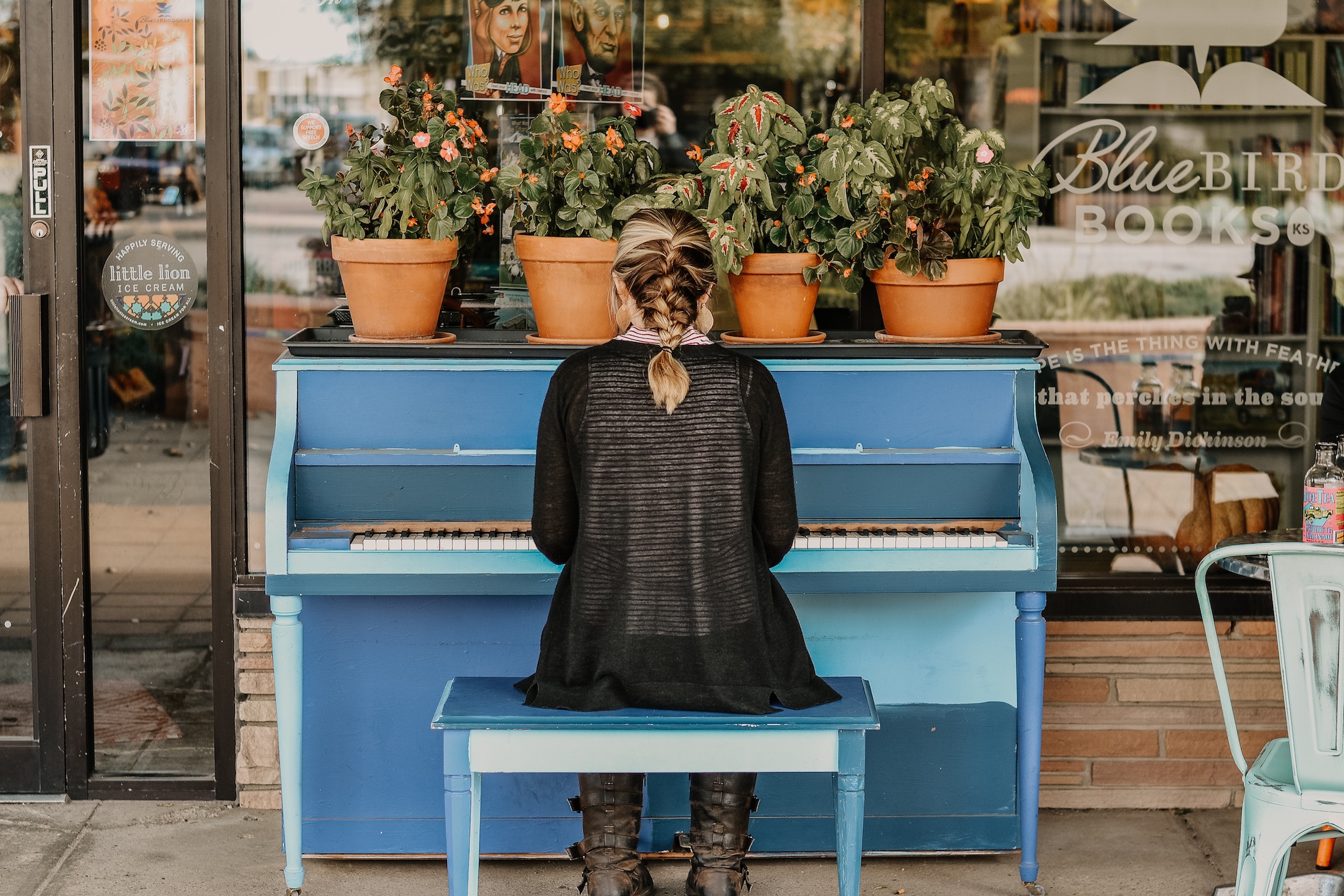 Woman playing piano outside Bluebird Bookstore in Hutchinson, Kan