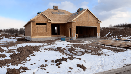 Home under construction in cold climate with snow on the ground