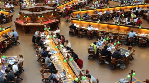 University library with rows of students working on laptops