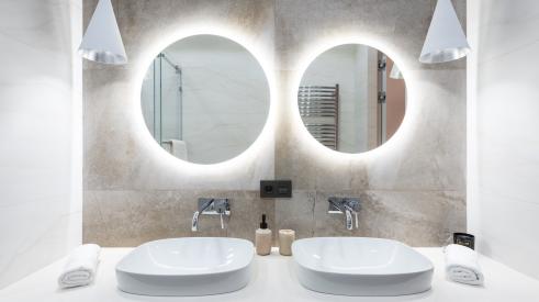 Twin bathroom mirrors with lighting around the back