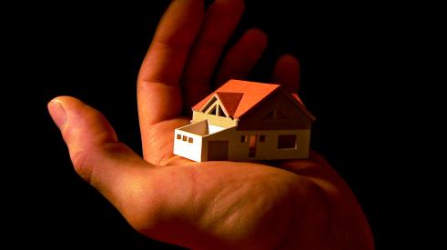 House model in the palm of a man's hand
