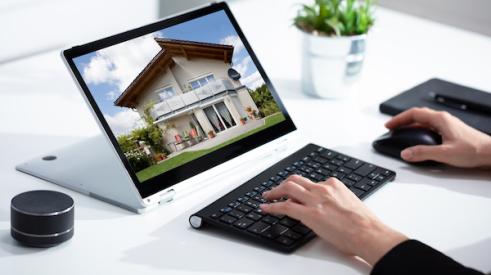 Person viewing an online listing of a home for sale