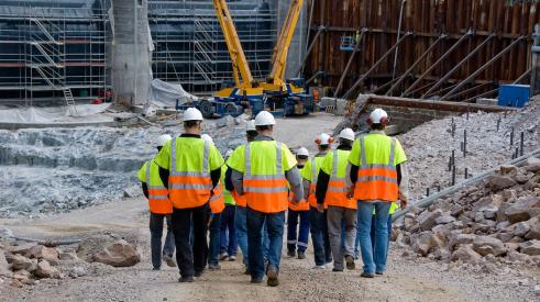 Group of construction workers walking to building site