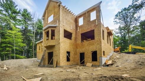 Single-family home construction site with framing almost complete