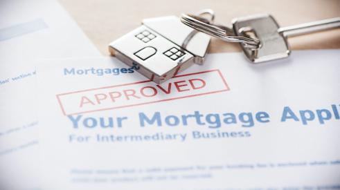Approved mortgage application with house keys