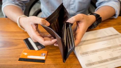 Gen Zer looks through wallet while going over bills